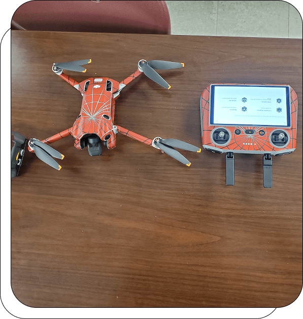 Red drone and controller on wooden table.