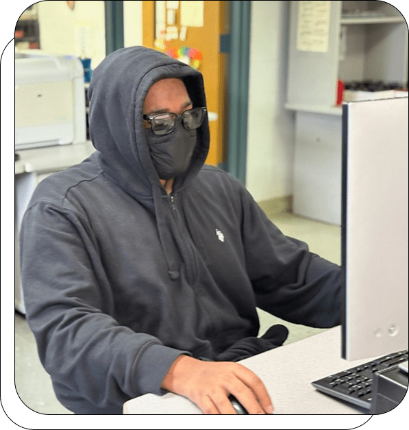 Person in hoodie using a computer.